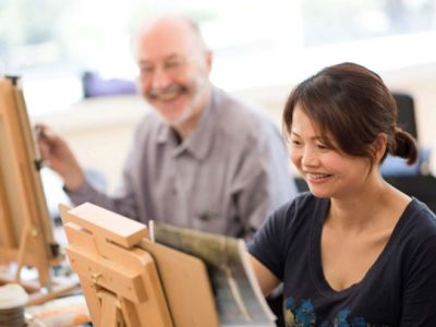 Two people painting at an easel